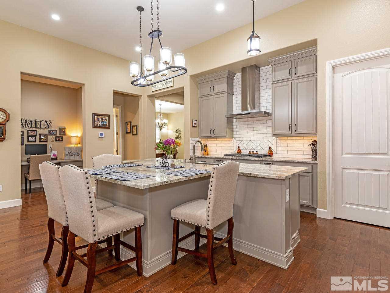 9455 Baldacci Road Reno, NV 89521 - Photo 10 of 22 a kitchen with kitchen island granite countertop a sink cabinets and wooden floor