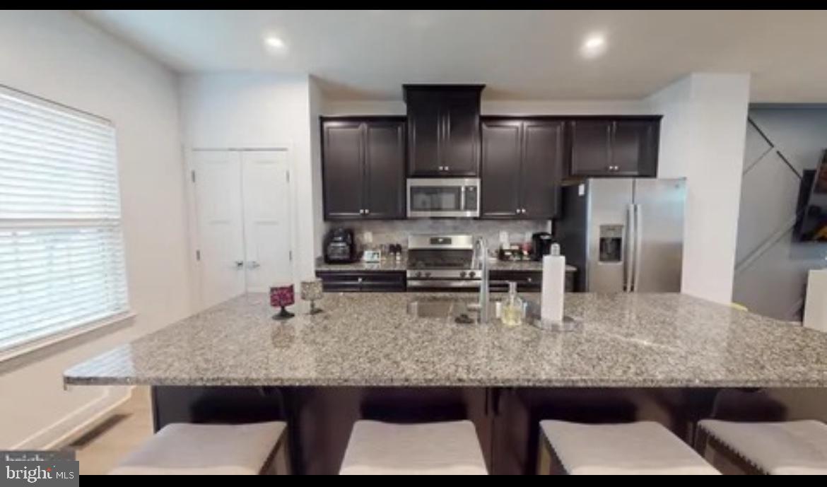 8002 General Greene Street Brandywine, MD 20613 - Photo 5 of 16 a kitchen with kitchen island granite countertop a sink and refrigerator
