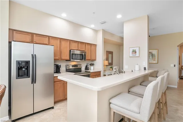 a kitchen with stainless steel appliances a refrigerator sink and microwave