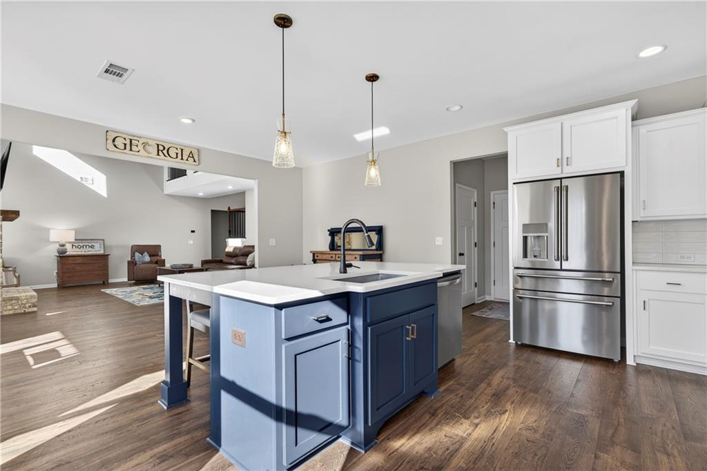 103 Hammond Road Griffin, GA 30223 - Photo 47 of 76 a kitchen with stainless steel appliances a sink a stove a refrigerator and island with wooden floor