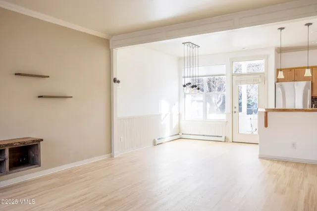 a view of a big room with wooden floor and windows