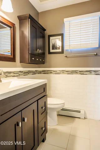 a bathroom with a sink a toilet and mirror