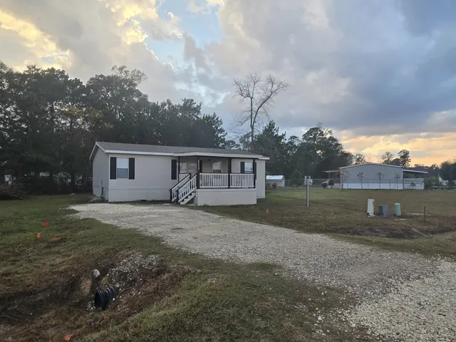 a view of backyard of house with green space