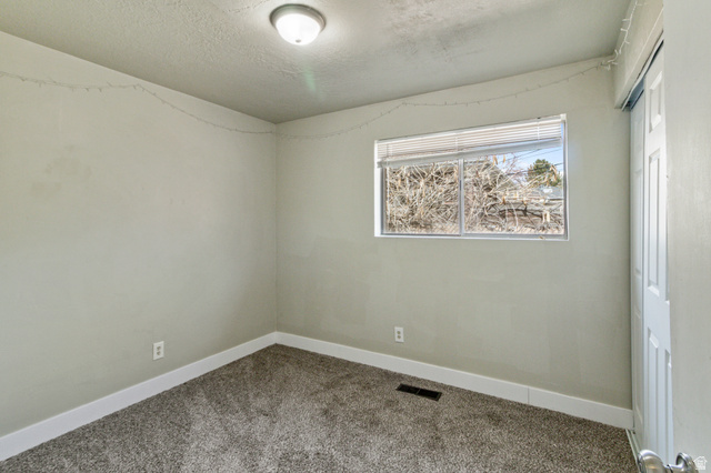 386 North 500 East Provo, UT 84606 - Photo 15 of 24 Carpeted empty room featuring baseboards and a textured ceiling