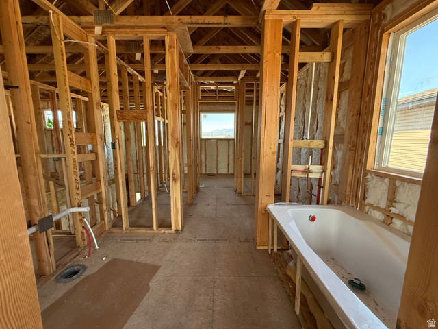 3318 South 1000 West Logan, UT 84321 - Photo 10 of 12 Interior framing with a built-in tub, multiple window openings, exposed ceiling joists, and visible insulation