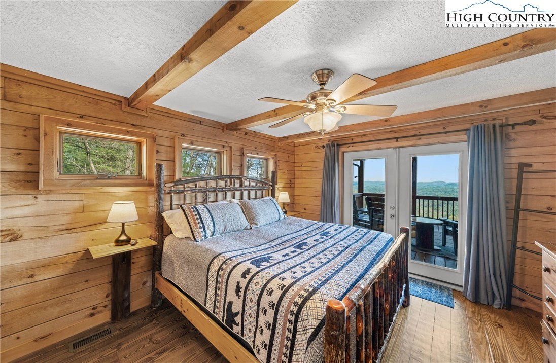 196 Eagle Nest Road Purlear, NC 28665 - Photo 20 of 36 a bedroom with a large bed and a chandelier