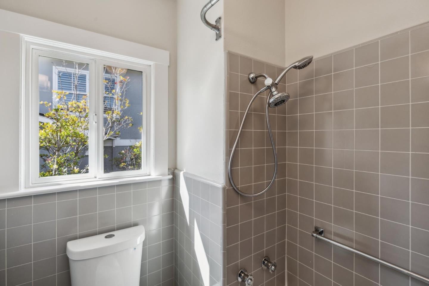 829 Edgehill Drive Burlingame, CA 94010 - Photo 51 of 99 a bathroom with a window a toilet a sink and a shower