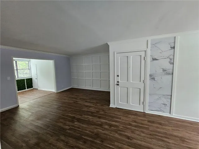 a view of empty room with wooden floor and window
