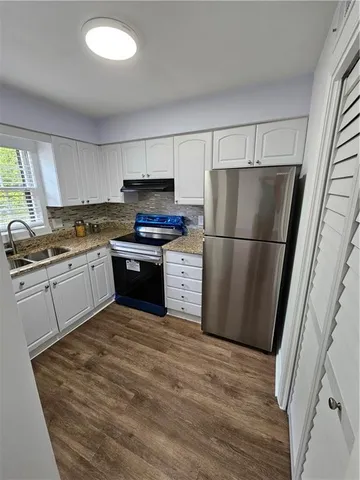 a kitchen with a refrigerator a sink and a stove top oven