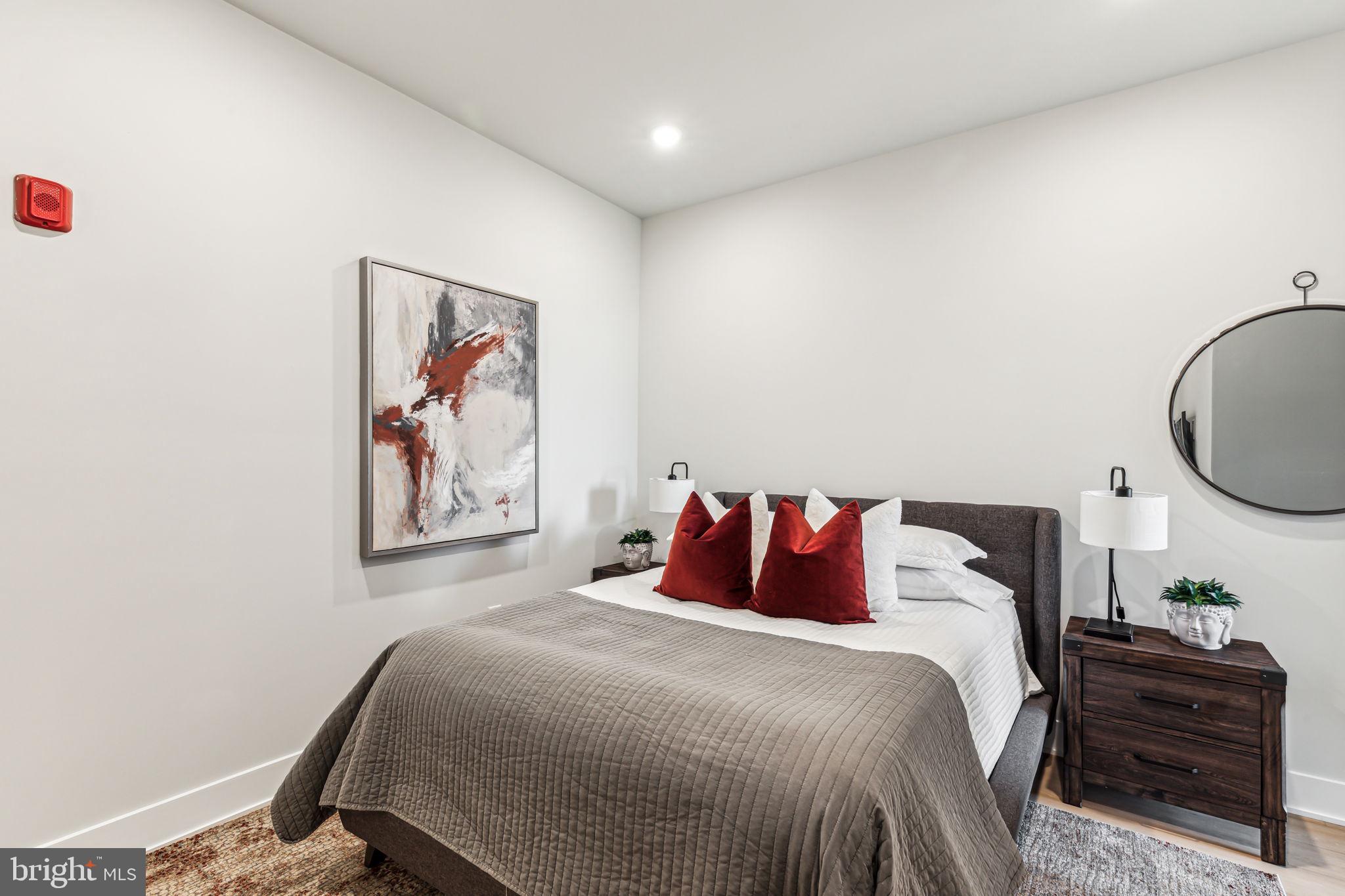 6910 Ridge Avenue, Unit 219 Philadelphia, PA 19128 - Photo 6 of 11 a bedroom with a bed and a painting on the wall