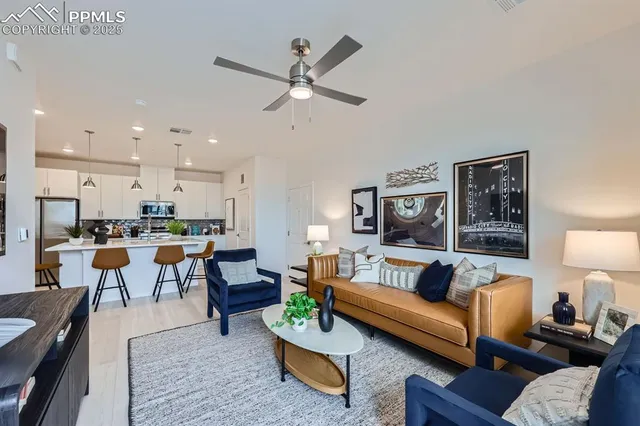a living room with furniture kitchen view and a lamp