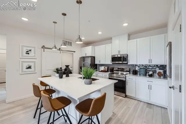 a kitchen with kitchen island a stove a table and chairs in it