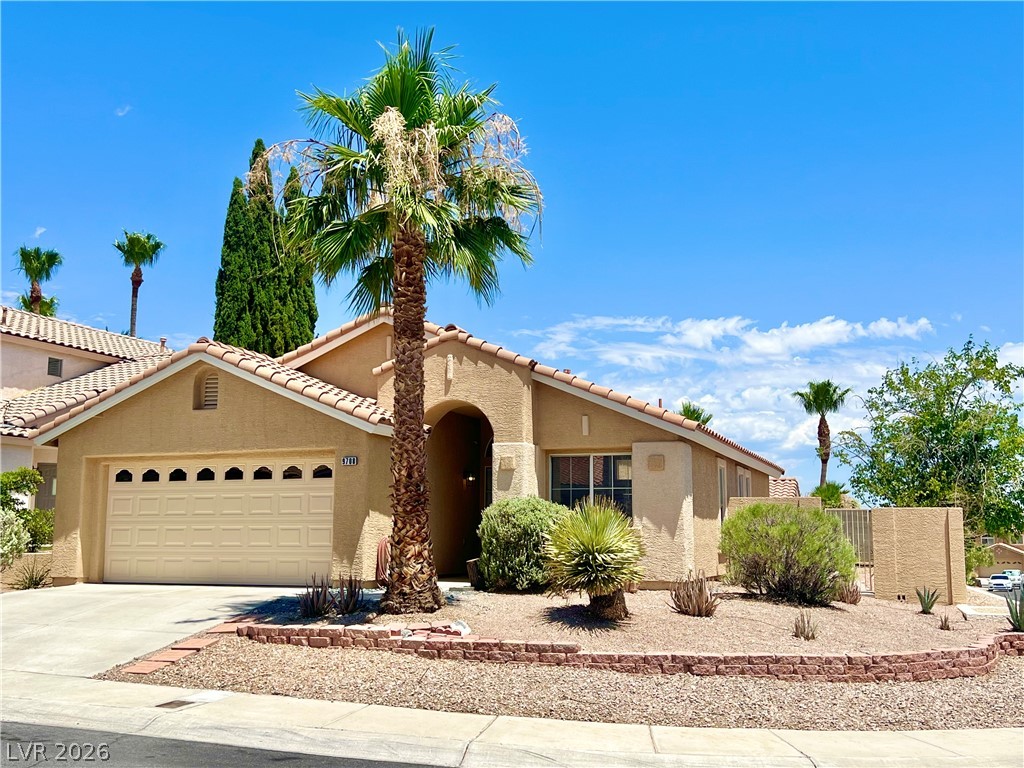 9708 Ridge Creek Place Las Vegas, NV 89134 - Photo 3 of 34 A well-maintained desert landscape frames this single-story home with a tile roof.