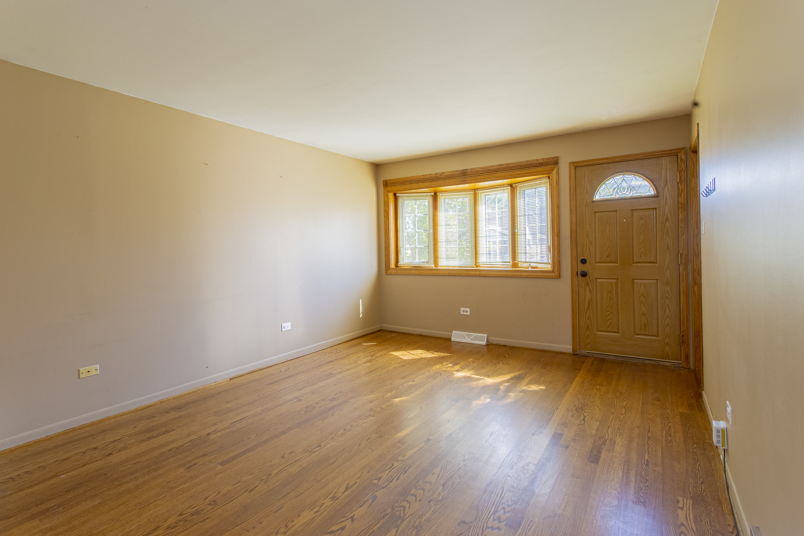 11040 Massasoit Avenue Chicago Ridge, IL 60415 - Photo 3 of 23 a view of an empty room with wooden floor and a window