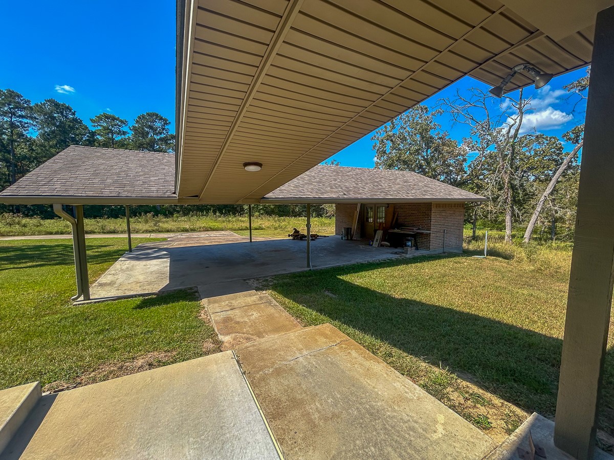 50 Neiderhoffer Subdivision Road Huntsville, TX 77340 - Photo 19 of 20 a view of a patio with table and chairs under an umbrella