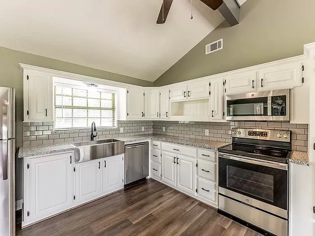 a kitchen with stainless steel appliances a stove sink and cabinets