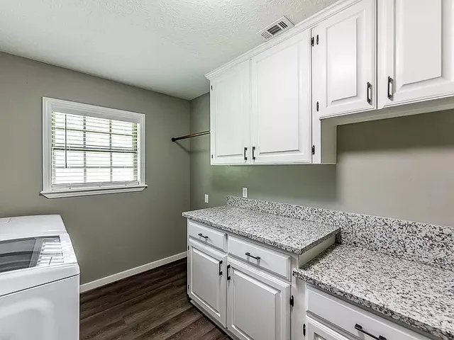 a kitchen with granite countertop white cabinets and white appliances