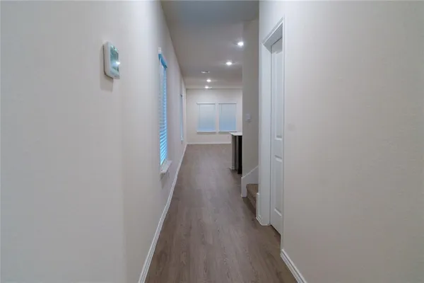 a view of a hallway with wooden floor