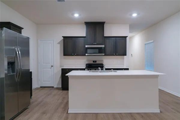 a kitchen with stainless steel appliances a refrigerator a stove top oven a sink and dishwasher