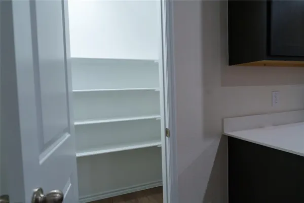 a view of walk in closet with empty racks