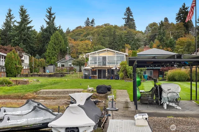 a view of a lake with a yard and a wooden fence