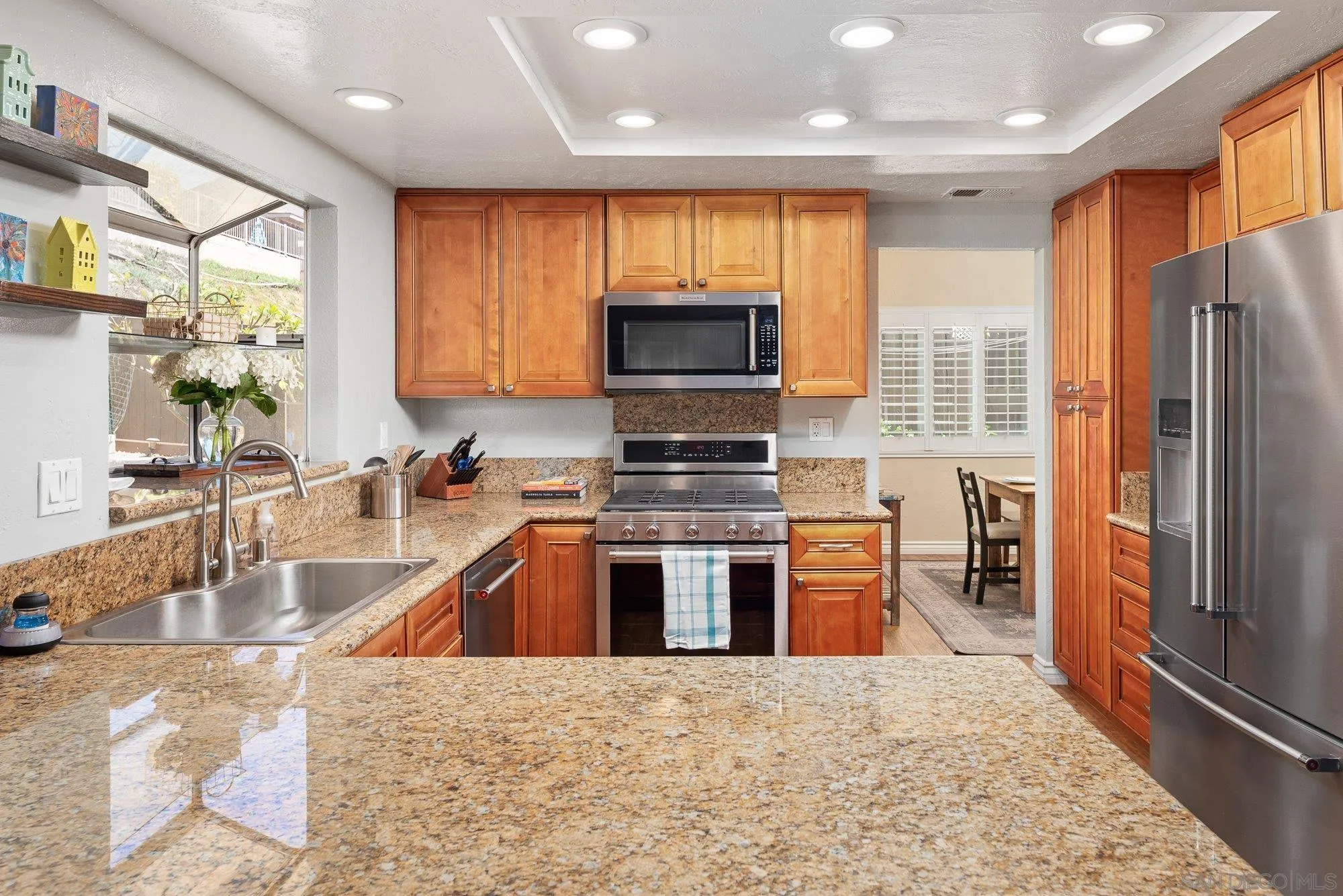 10246 Princess Joann Road Santee, CA 92071 - Photo 12 of 48 a kitchen with stainless steel appliances granite countertop a refrigerator a stove top oven a sink and dishwasher