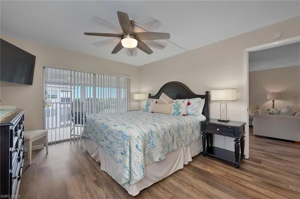 a bedroom with a bed a flat screen tv and a chandelier