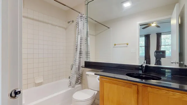 a bathroom with a sink a toilet a mirror and bathtub
