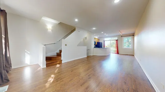 a view of a hallway with wooden floor and seating space