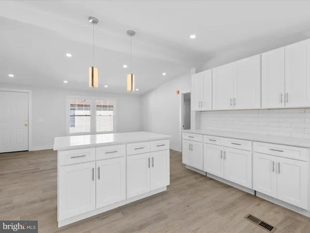 a kitchen with white cabinets and white appliances