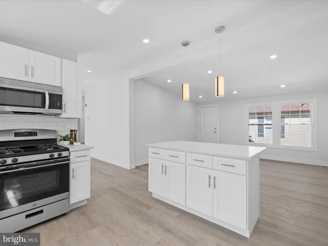 a kitchen with white cabinets and sink