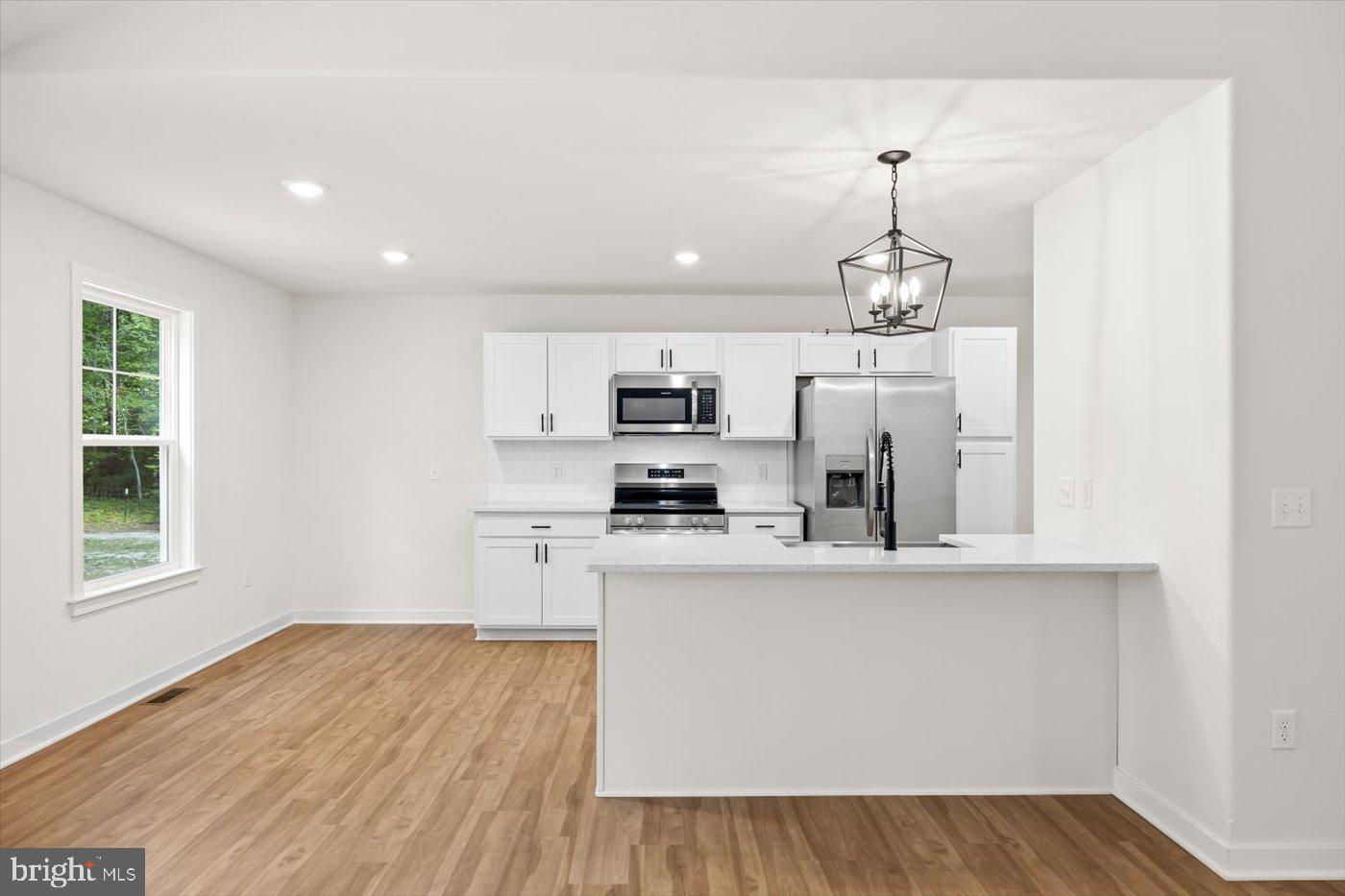 736 Circle Lane Colonial Beach, VA 22443 - Photo 14 of 40 a kitchen with stainless steel appliances granite countertop a refrigerator a stove oven a sink dishwasher and white cabinets with wooden floor