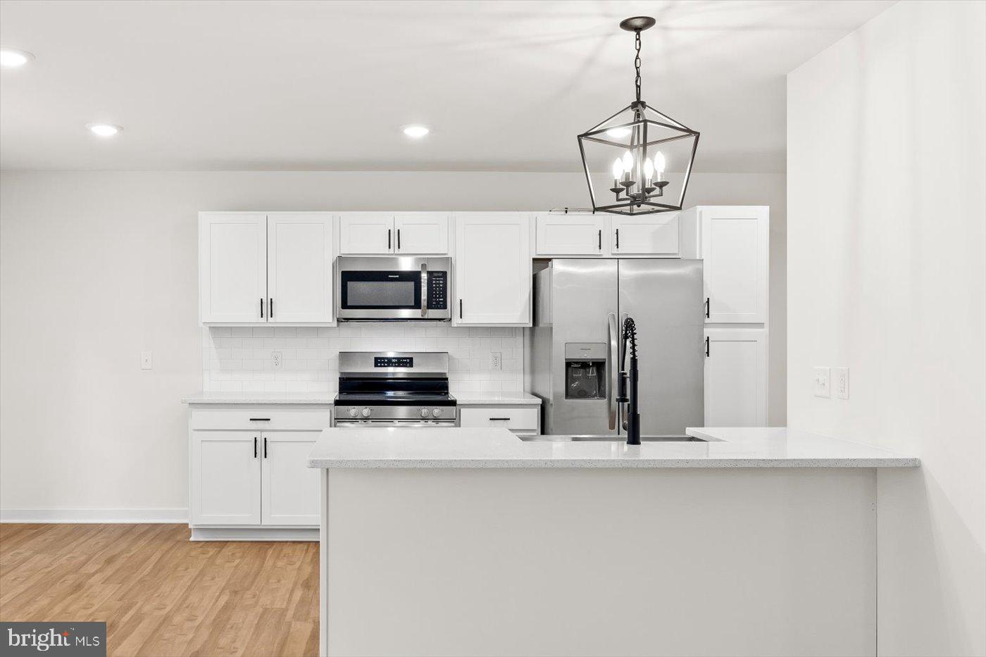 736 Circle Lane Colonial Beach, VA 22443 - Photo 15 of 40 a kitchen with stainless steel appliances granite countertop a sink a microwave a refrigerator and white cabinets