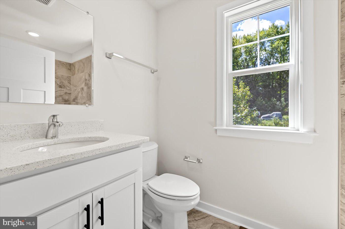 736 Circle Lane Colonial Beach, VA 22443 - Photo 28 of 40 a bathroom with a granite countertop toilet a sink and a window