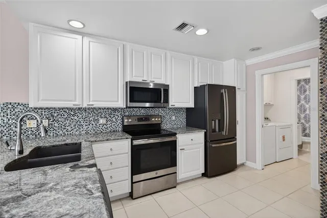 a kitchen with stainless steel appliances a stove a refrigerator and a microwave