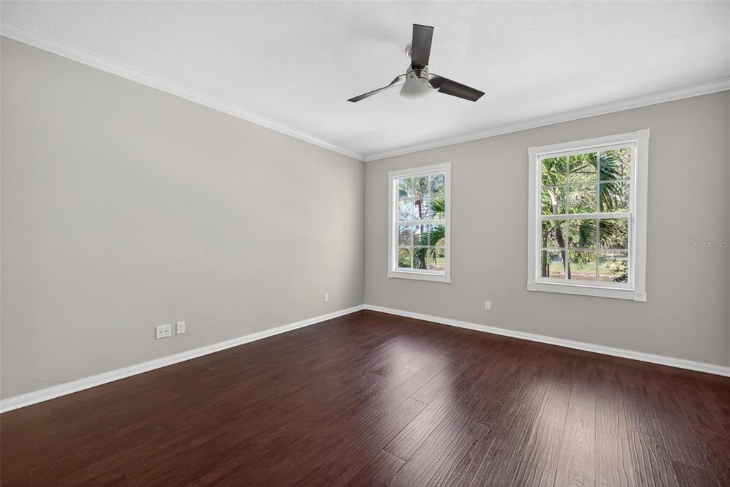 3518 Zanzibar Way Naples, FL 34119 - Photo 16 of 44 a view of empty room with wooden floor and fan