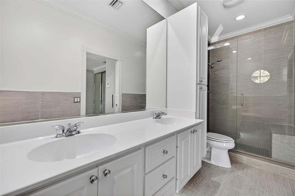3518 Zanzibar Way Naples, FL 34119 - Photo 20 of 44 a bathroom with a double vanity sink toilet and a mirror
