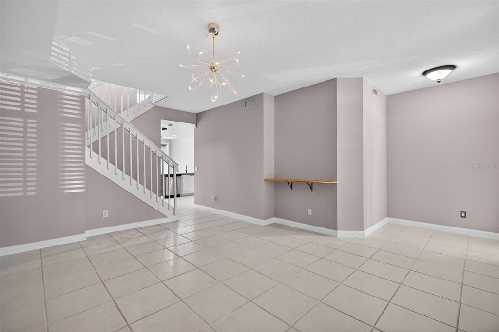 3518 Zanzibar Way Naples, FL 34119 - Photo 5 of 44 a view of an empty room with stairs and a chandelier fan