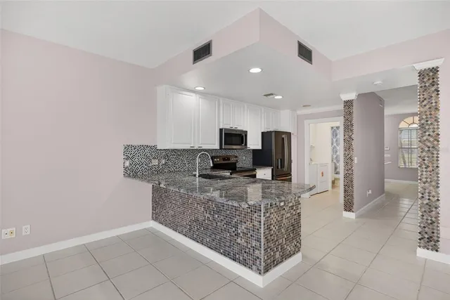 a kitchen with stainless steel appliances granite countertop a refrigerator and a counter space