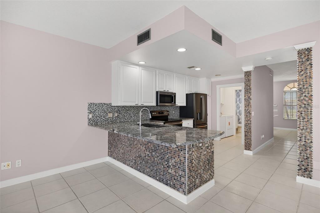 3518 Zanzibar Way Naples, FL 34119 - Photo 9 of 44 a kitchen with stainless steel appliances granite countertop a refrigerator and a counter space