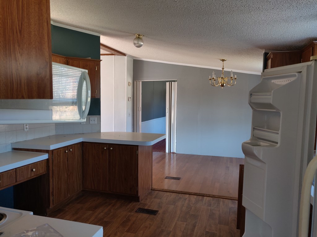411 Scott Road Elko, GA 31025 - Photo 14 of 27 a kitchen with a sink a refrigerator and wooden cabinets