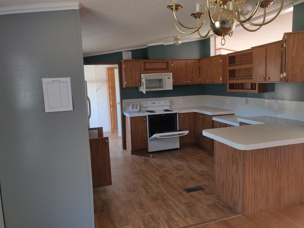 411 Scott Road Elko, GA 31025 - Photo 15 of 27 a kitchen with stainless steel appliances granite countertop a sink a stove and a wooden floors