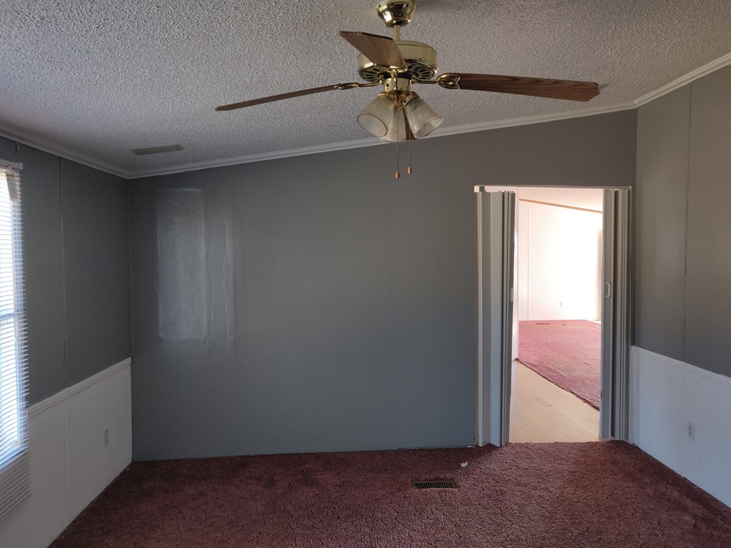 411 Scott Road Elko, GA 31025 - Photo 19 of 27 an empty room with a window and a ceiling fan