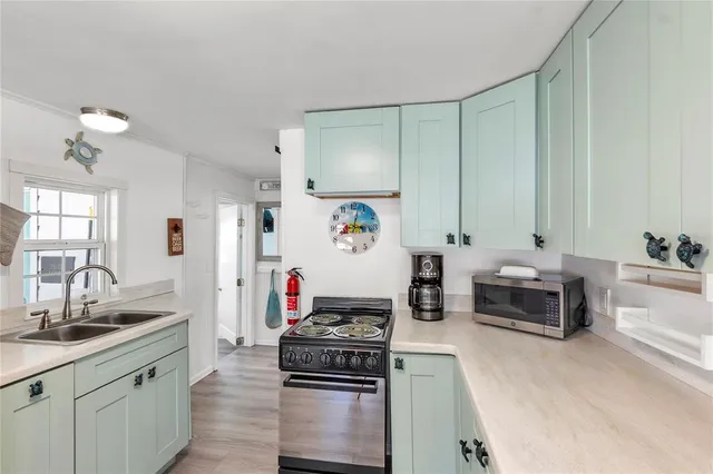 a kitchen with stainless steel appliances a stove a sink and a refrigerator