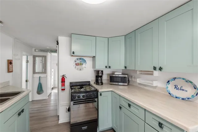 a kitchen with stove a sink and cabinets