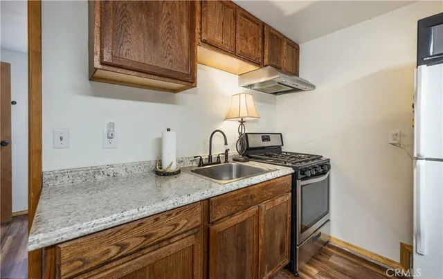 a kitchen with stainless steel appliances granite countertop a sink a stove and cabinets