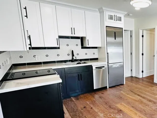 a kitchen with a refrigerator sink and cabinets
