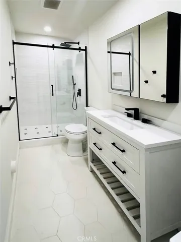 a bathroom with a sink a toilet and shower