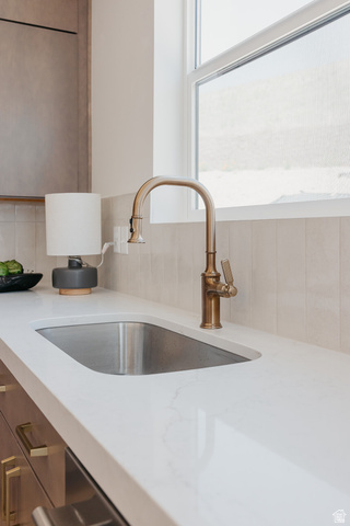 5902 Canyon Rim Road, Unit 620 Lehi, UT 84048 - Photo 14 of 78 Kitchen sink featuring a brushed brass faucet, integrated stainless steel basin, and solid surface countertop