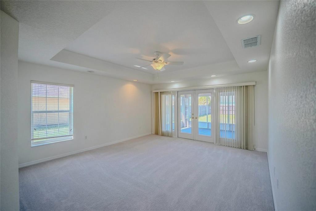 6598 Southeast 11th Loop Ocala, FL 34472 - Photo 13 of 49 an empty room with windows and chandelier fan